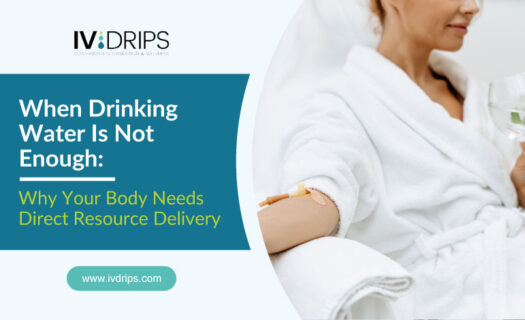 A woman in a white robe receives an IV drip in her arm while holding a glass of water. Text on the image reads: “When Drinking Water Is Not Enough: Why Your Body Needs Direct Resource Delivery. www.ivdrips.com.”.