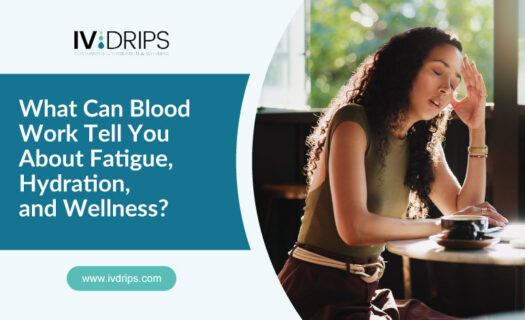 A woman sits at a table, looking fatigued with her hand on her forehead. Text on the image reads: “What Can Blood Work Tell You About Fatigue, Hydration, and Wellness?” and a website link: www.ivdrips.com.