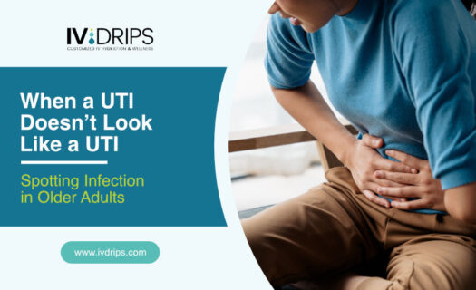 A woman in a blue shirt sits holding her stomach in discomfort, highlighting UTI symptoms in older adults. Text reads: When a UTI Doesn’t Look Like a UTI—Spotting Infection in Older Adults. IV Drips logo and website are also shown.